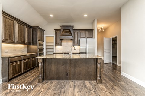 A kitchen with dark wood cabinets and a center island.
