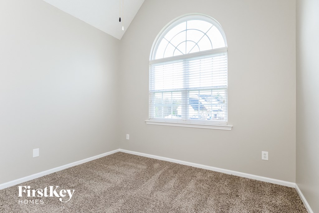 the second bedroom has carpet and a large window
