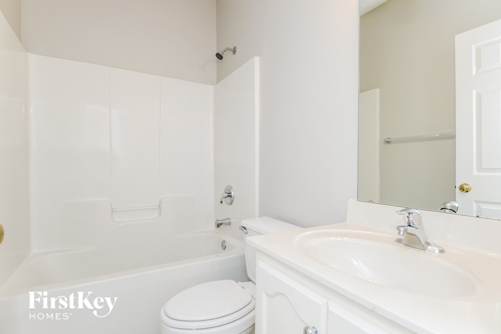 a white bathroom with a sink toilet and bath tub