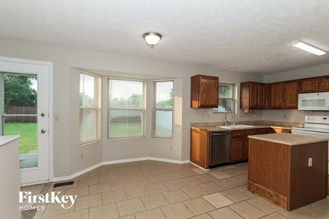 A kitchen with brown cabinets and a white fridge.