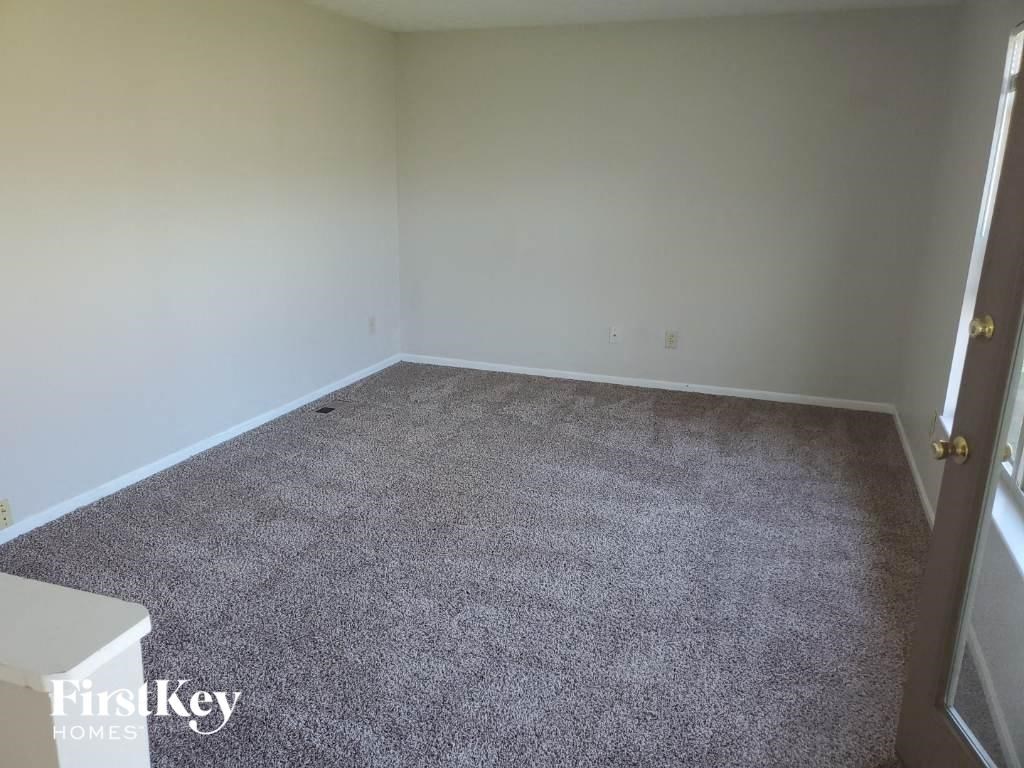 A room with a grey carpet and a white door.