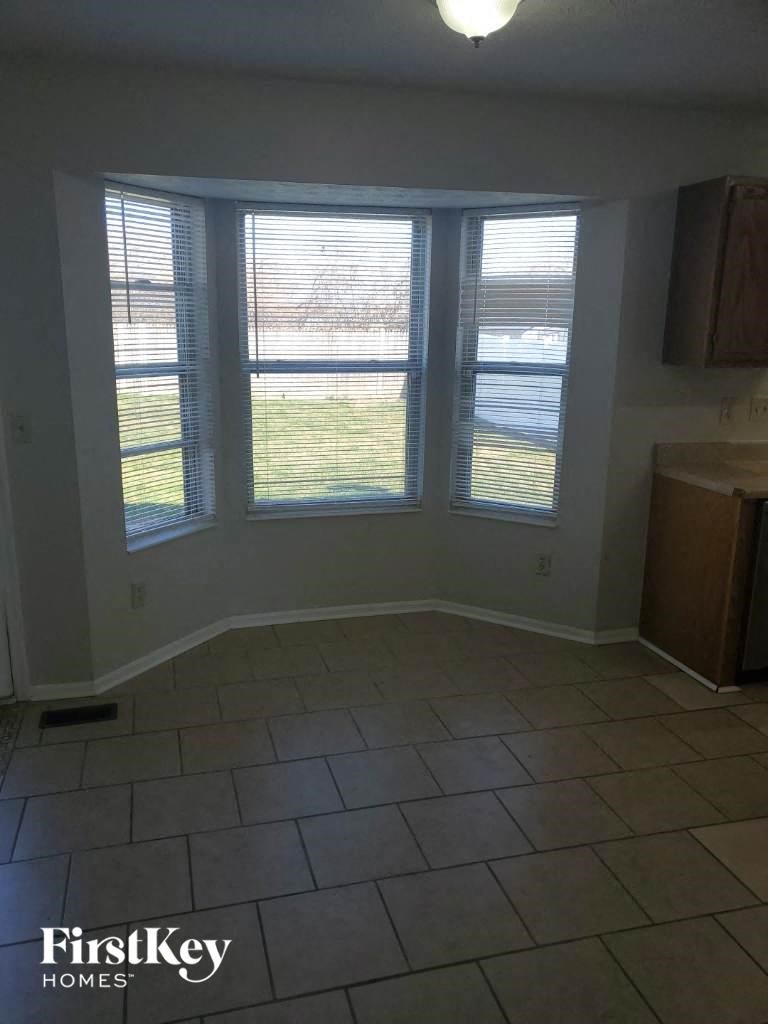 A room with a large window and a tiled floor.