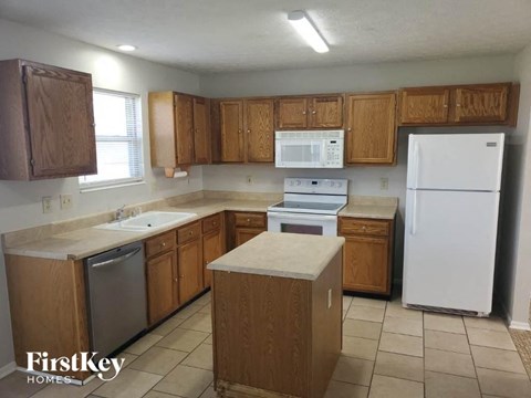 A kitchen with wooden cabinets and a white refrigerator.
