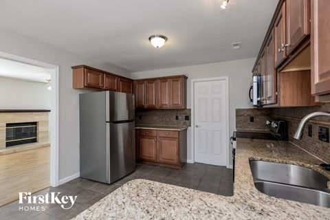 A kitchen with a stainless steel refrigerator and wooden cabinets.