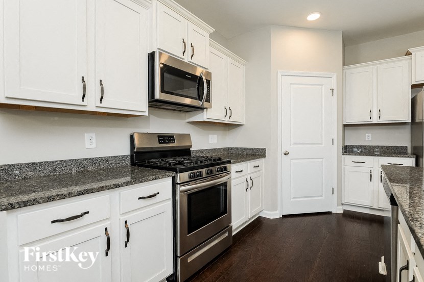 a kitchen with white cabinets and stainless steel appliances