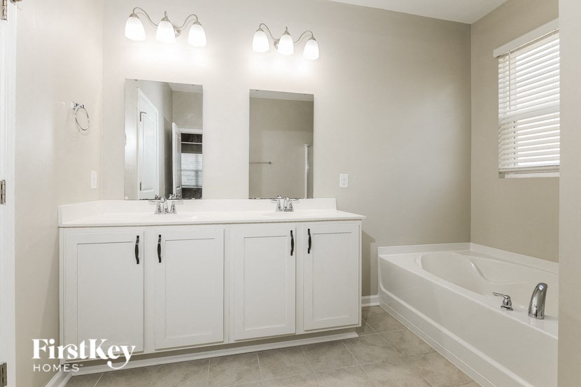 a bathroom with a sink and a tub and a mirror