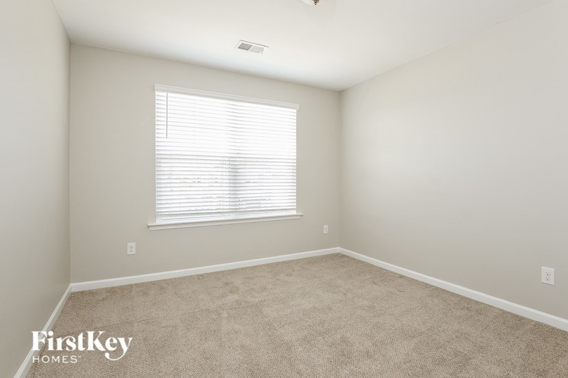 an empty room with a window and carpet