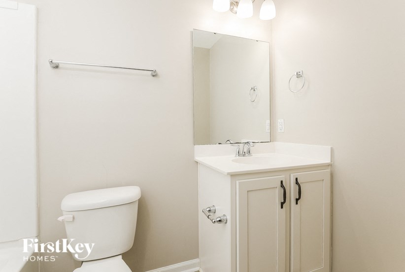 a bathroom with a toilet and a sink and a mirror