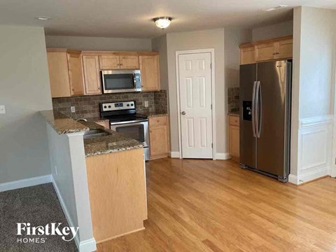 a kitchen with wooden floors and stainless steel appliances