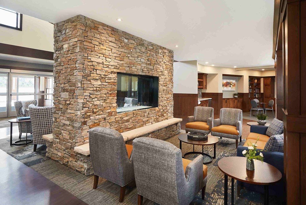 a lobby of a hotel with chairs and a fireplace