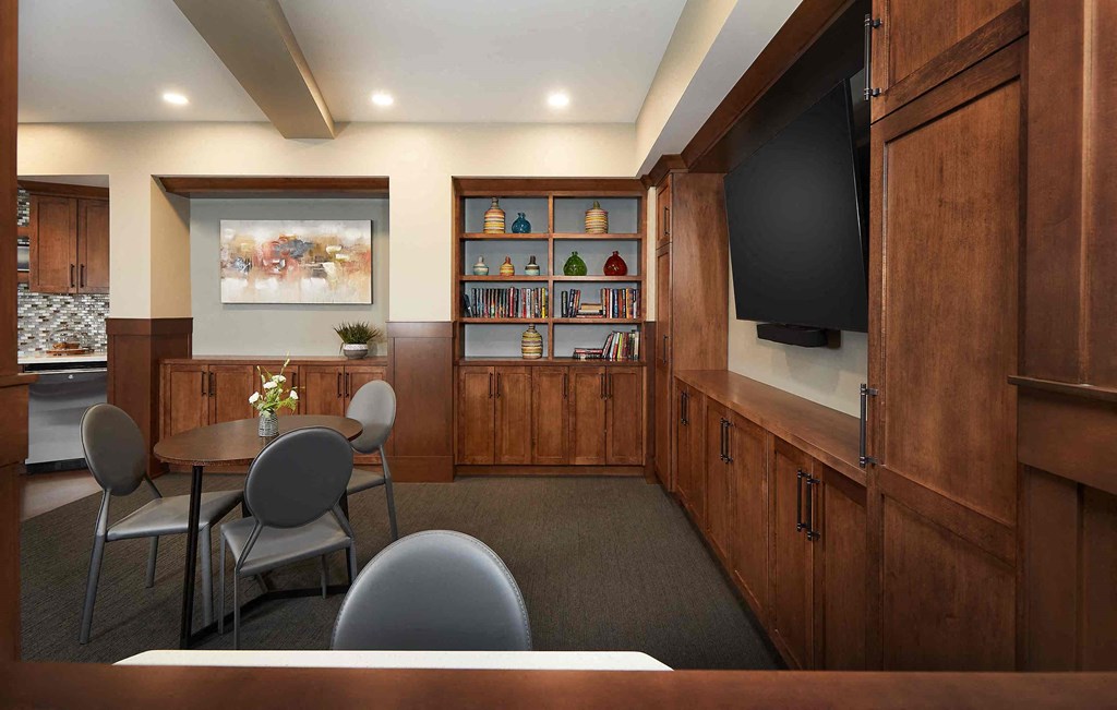 a conference room with a table and chairs and a television