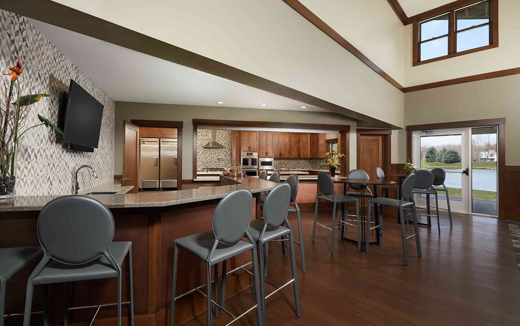 a large kitchen and dining room with a bar and chairs