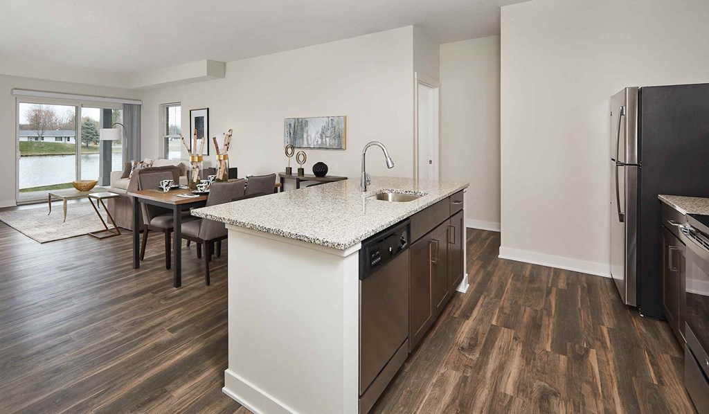 a kitchen and living room with a table and a refrigerator
