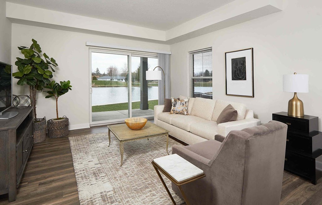a living room with a couch and a chair in front of a window