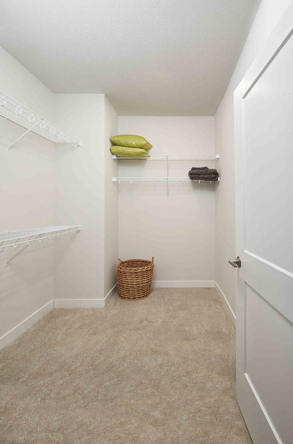 a walk in closet in a bathroom with a shower and a basket