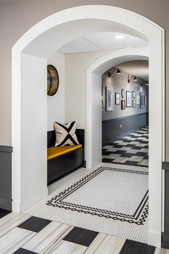 a hallway with a checkered floor and a yellow couch
