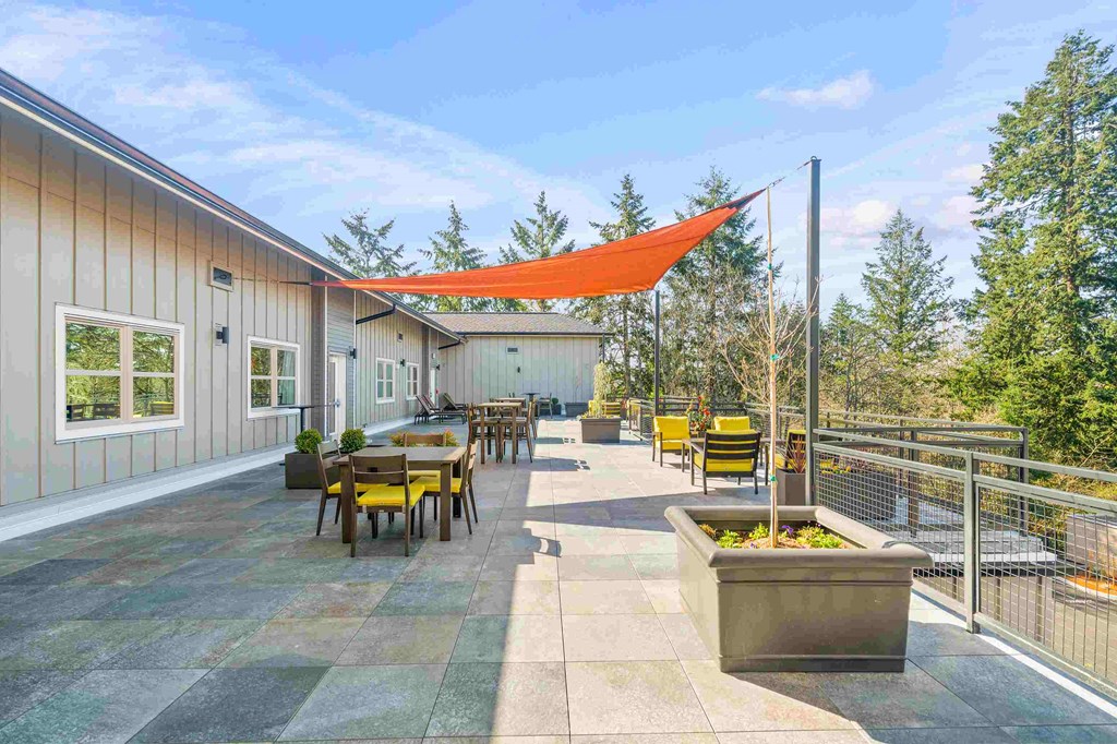 a patio with tables and chairs and a orange canopy