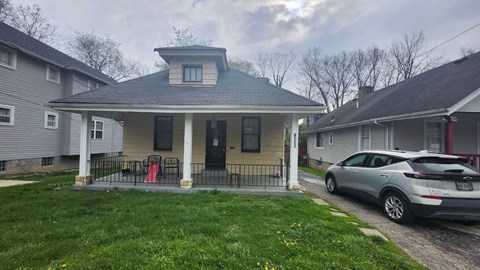A house with a car parked in front.