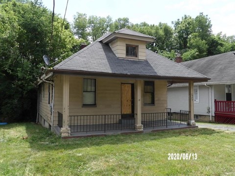 A house with a porch and a black iron fence.
