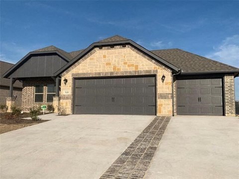 A house with a garage and a driveway in front.