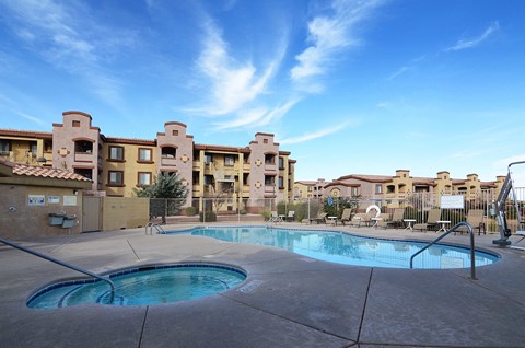 a swimming pool with an apartment building in the background