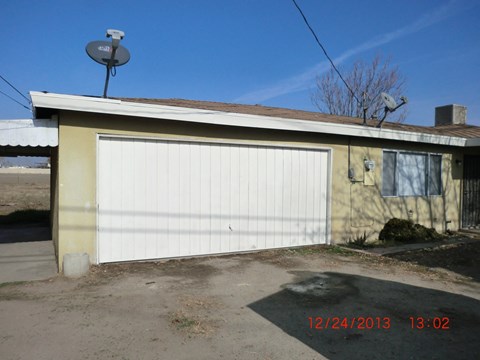 the front of a garage with a white garage door