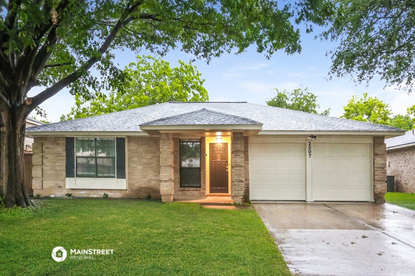 front view of a brick house with a tree
