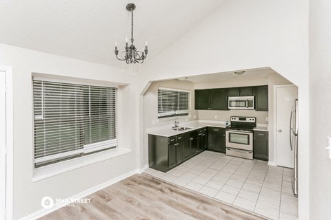 a kitchen with black and white cabinets and a window