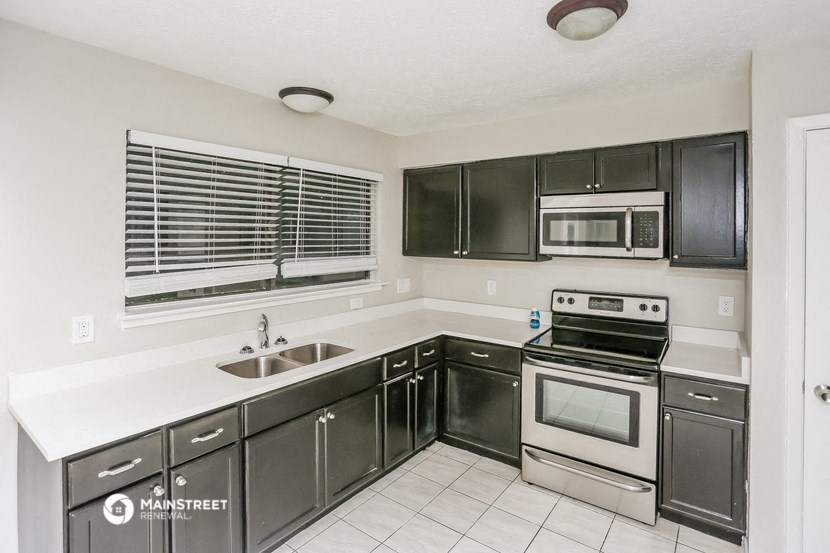 a kitchen with stainless steel appliances and black cabinets