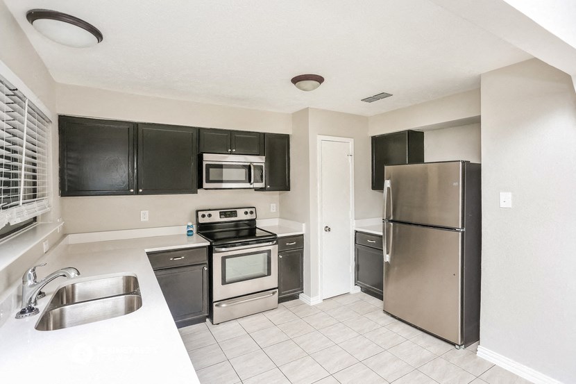 a kitchen with stainless steel appliances and black cabinets