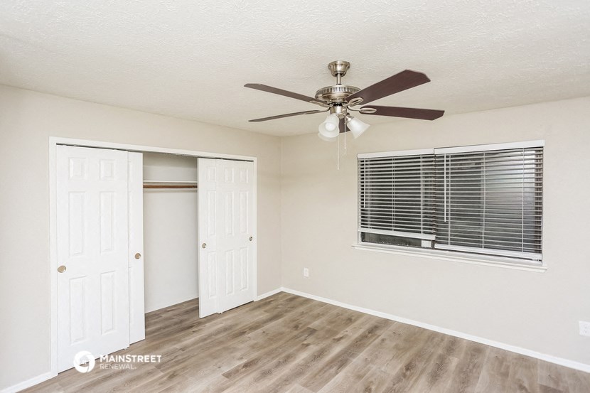 the living room of our studio apartment atrium with ceiling fan and closet