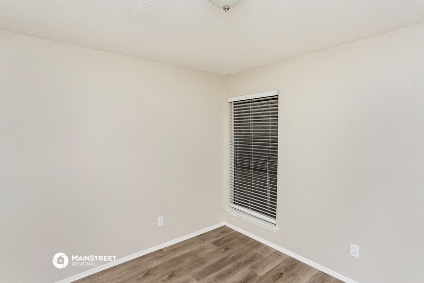 the bedroom of our studio apartment atrium with wood flooring and a window