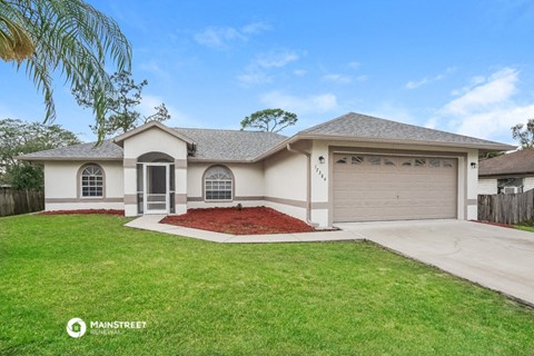 a beige house with a garage and a lawn