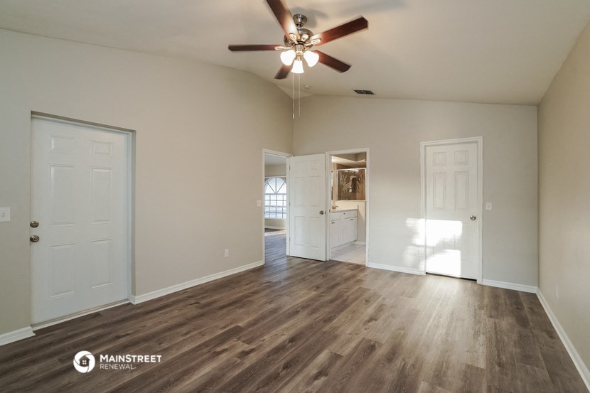 the living room of an empty house with a ceiling fan