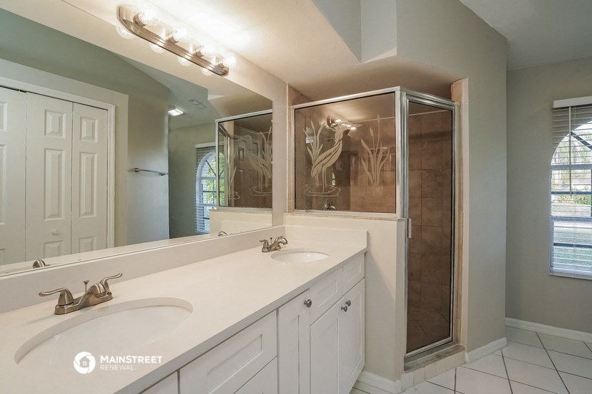 a bathroom with two sinks and a shower