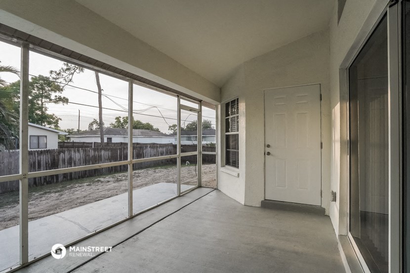 the view from the living room of a house with large windows and a white door