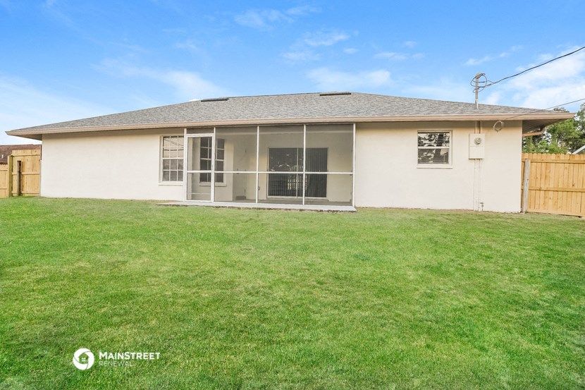 the backyard of a house with a lawn and a fence