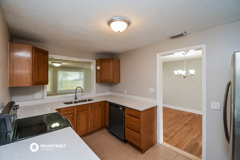 a kitchen with wooden cabinets and a sink and a refrigerator