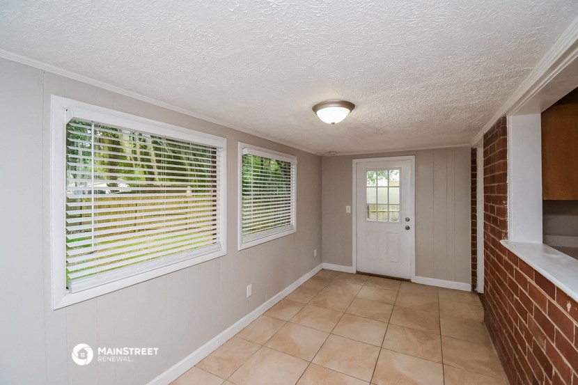 the dining room has a brick wall and a large window