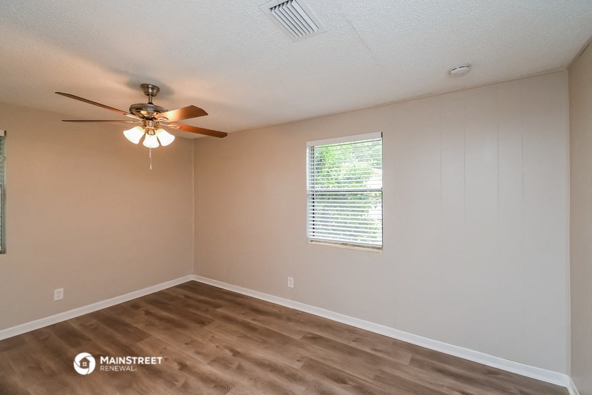 the interior of a bedroom with a ceiling fan and a window