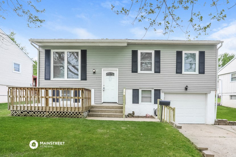 a gray house with a white door and a porch