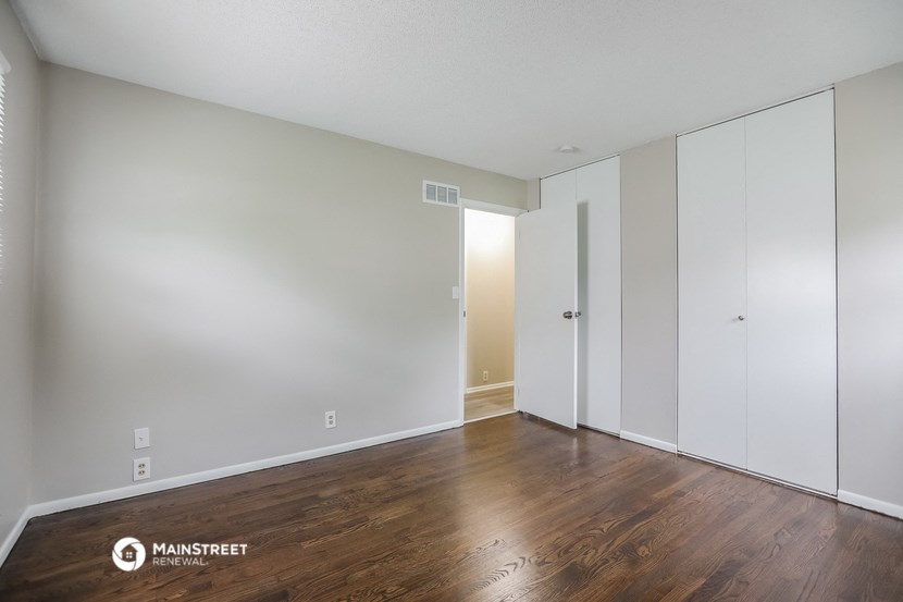 an empty living room with white walls and wood floors