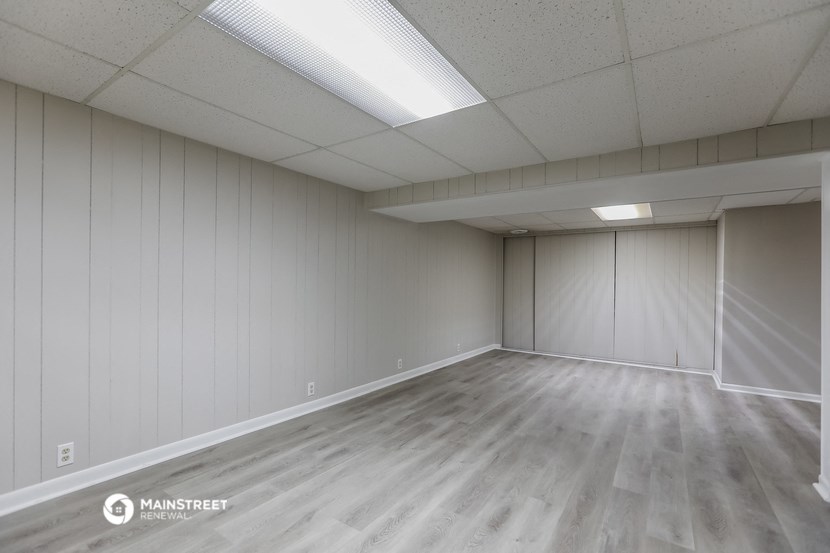 the interior of an empty room with wood floors and white walls