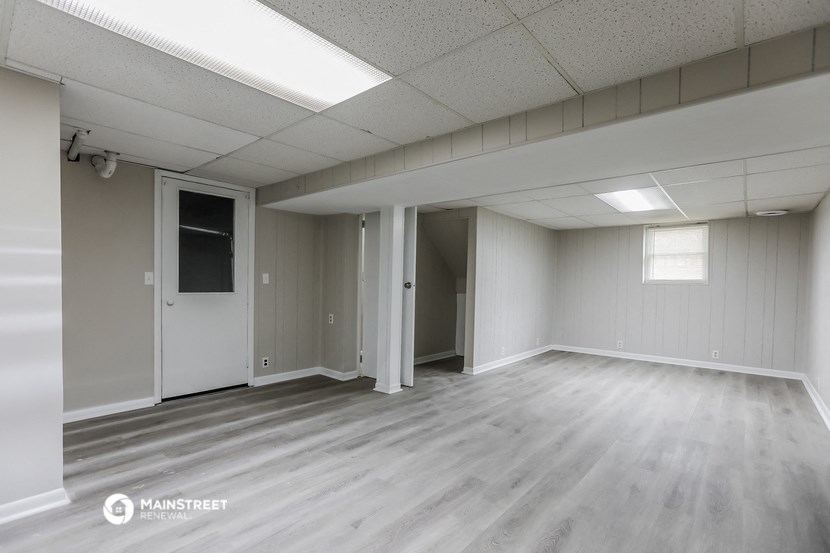 an empty living room with white walls and wood floors