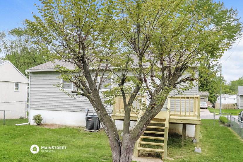a house with a deck and a tree in the yard