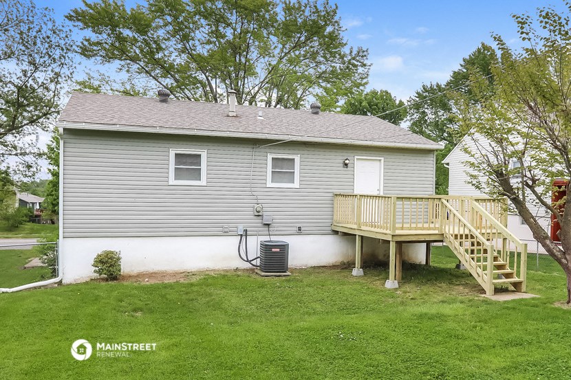 the back of a house with a deck and a backdoor