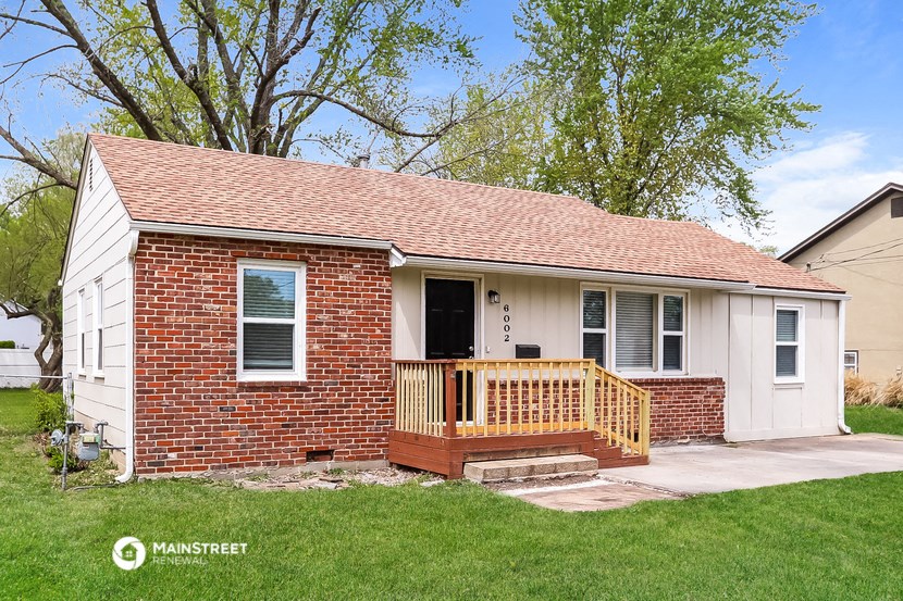 a small brick house with a deck and a porch
