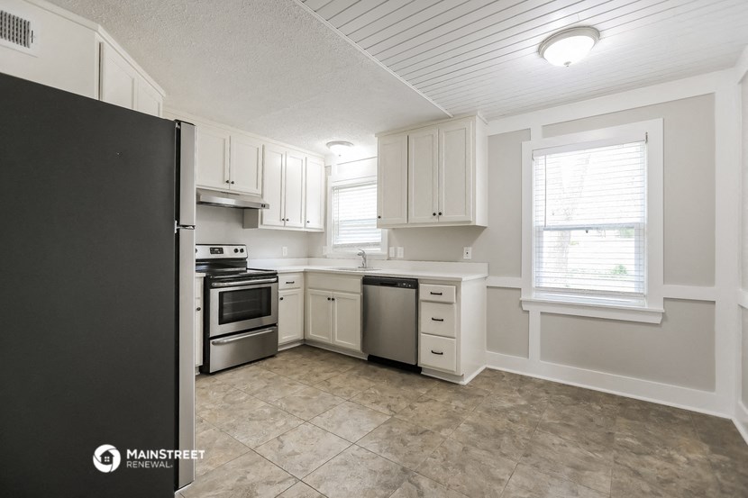 a kitchen with white cabinets and stainless steel appliances