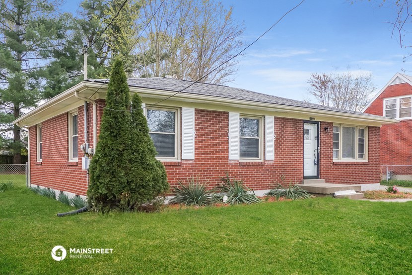 a red brick house with a white door and a green yard