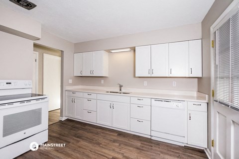 a kitchen with white cabinets and a stove and a sink